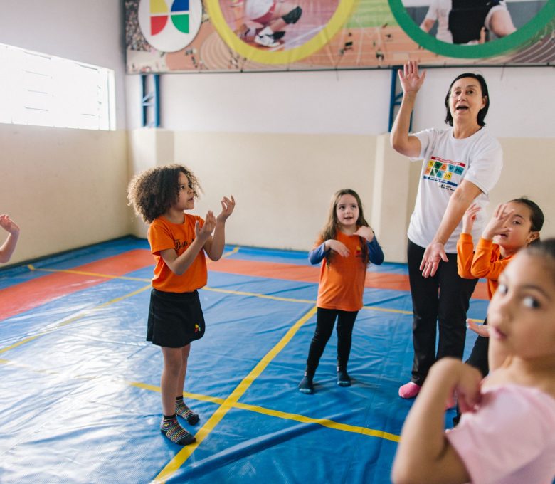 Professora instrue crianças em atividade extra - Escola Bem Melhor